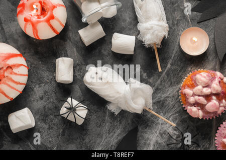 Kreative Desserts mit Marshmallows und Cupcakes für Halloween Party auf grauem Hintergrund vorbereitet Stockfoto