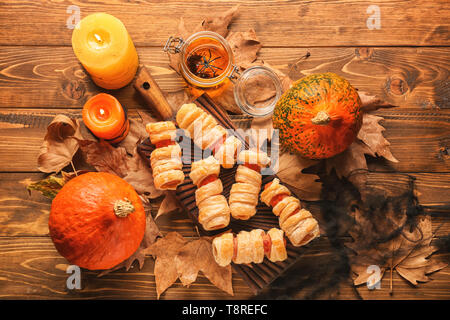 Zusammensetzung mit Nahrungsmitteln und brennende Kerzen für Halloween Party auf hölzernen Hintergrund vorbereitet Stockfoto