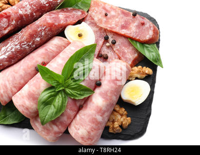 Schiefer Platte mit verschiedenen Arten von Würstchen auf weißem Hintergrund Stockfoto