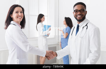 Willkommen an Bord. Verschiedene Ärzte die Hände schütteln Stockfoto