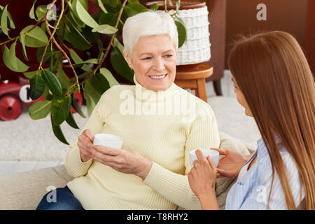 Frau besuchen ältere Mutter und Kaffee Stockfoto