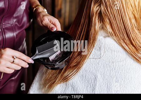 Professionelle friseure Bürsten nasser Haare der schöne junge blonde Frau vor dem Färben Haare. Haarpflege Produkte, Gesundheit und Schönheit. Nahaufnahme der Stockfoto