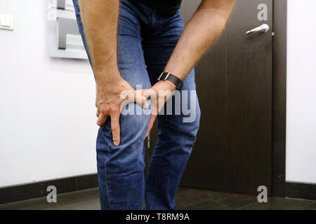 Der junge Mann leidet unter Knieschmerzen. Sport Verletzungen, Luxation, Verstauchung. Entzündete knie Bänder. Stockfoto