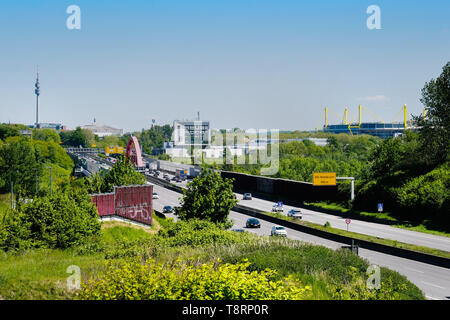 Skyline von Dortmund, mit der Autobahn A40 (Ruhrschnellweg) in Dortmund als Bundesstraße Nr. 1 mit Fußball-Arena Westfalenstadion (Signal Iduna Park), Westfalenhalle und Fernsehturm Florianturm im Westfalenpark. Stockfoto