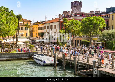 SIRMIONE, Gardasee, Italien - September 2018: Menschen auf der Hafenseite in Sirmione am Gardasee. Stockfoto