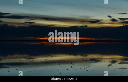 Letzten Sonnenstrahlen Sonnenuntergang auf dem Salzsee von Salar de Uyuni, Bolivien Stockfoto