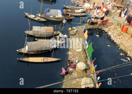 Gypsy Frauen und Mädchen, die auf Hausbooten leben, tun alle inländischen Reinigung in der Dunkelheit, verschmutztes Wasser des Flusses an Turag Tongi in Gazipur. Stockfoto