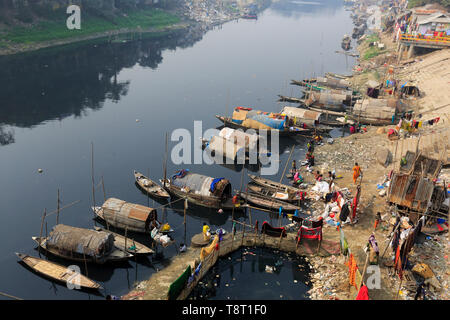 Gypsy Frauen und Mädchen, die auf Hausbooten leben, tun alle inländischen Reinigung in der Dunkelheit, verschmutztes Wasser des Flusses an Turag Tongi in Gazipur. Stockfoto