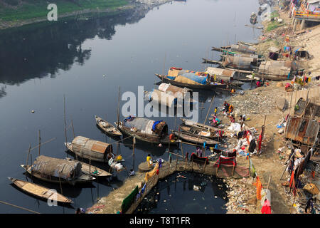 Gypsy Frauen und Mädchen, die auf Hausbooten leben, tun alle inländischen Reinigung in der Dunkelheit, verschmutztes Wasser des Flusses an Turag Tongi in Gazipur. Stockfoto