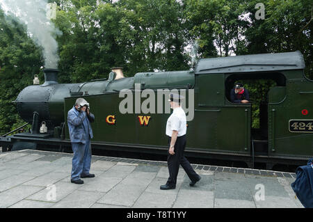 Station Master und Treiber neben GWR Klasse 2-8-0 T 4247 Zug am Bodmin Parkway Bahnhof Cornwall GROSSBRITANNIEN Stockfoto