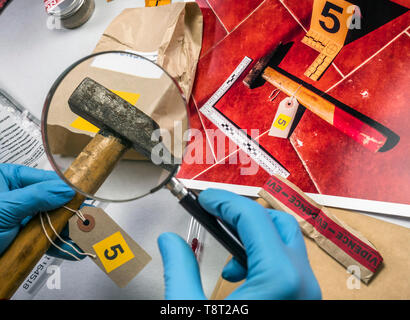 Experten der Polizei untersucht mit Lupe Hammer im Labor forensische Ausrüstung, konzeptionelle Bild Stockfoto