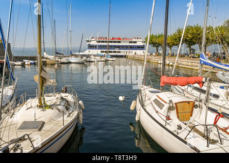 TORRI del Benaco, Gardasee, Italien - September 2018: Segelboote im Hafen in der Nähe von Torri del Benaco am Gardasee. Eine Passagierfähre ist Stockfoto