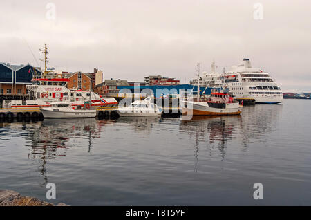 Hammerfest, Norwegen - 21. Januar 2010: Schiffe und Boote in See Dock am grauen Himmel. Wasser, Verkehr und Transport. Reisen mit Meerblick. Reiselust und Urlaub. Stockfoto