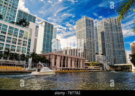 Skyline an bewölkten Himmel Hintergrund in Miami, USA. Wolkenkratzer und Yachtcharter Boote auf dem Fluss, brickell. Perspektive, Zukunft und Geschwindigkeit der Bewegung. Transport und Reisen Stockfoto