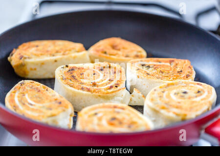 In der Nähe von frisch gegrillten Tortilla Wraps mit Füllung. Gebratene tortilla Rollen in der Pfanne. Selektiver Fokus Stockfoto