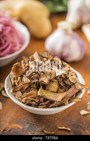 Getrocknete Pilze Saurer Kohl, Knoblauch und Kartoffeln auf hölzernen Tisch Stockfoto