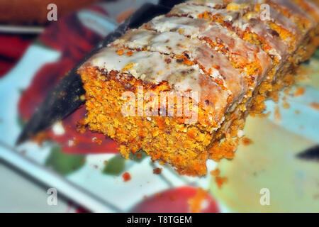 Hausgemachter Karottenkuchen, auf einer Platte geschnitten, können Sie deutlich die Karottenstücke sehen und saftigen der Kuchen ist in den Farben gelb und orange. Stockfoto
