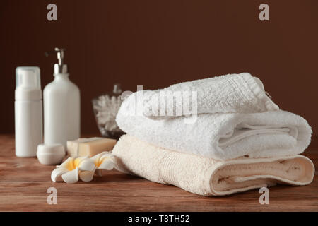 Stapel von weiche Handtücher und Kosmetika auf hölzernen Tisch Stockfoto