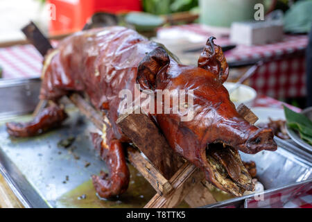 Gebratenes Schwein auf dem traditionellen Grill. Gegrilltes Schwein auf dem Markt von Bali, Indonesien, Nahaufnahme Stockfoto
