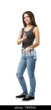 Junge Frau in ärmelloses Top und Jeans in Hälfte stehend - drehen Sie mit der linken Hand in der Tasche und mit der rechten Hand an der Viewer zeigt auf weißem Hintergrund. Stockfoto