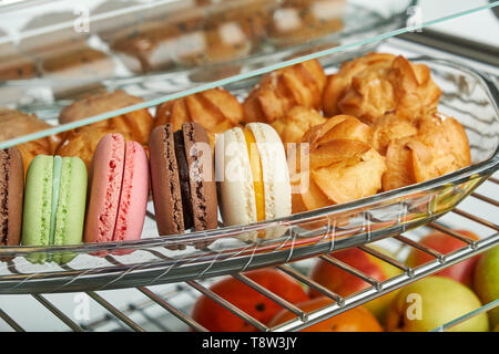 Schaufenster Kühlschrank für die Verpflegung mit warmen Speisen. Süße Desserts, warme Speisen und Salate. Stockfoto