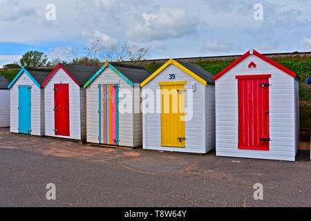 Eine bunte Reihe von bunten Badekabinen an der Strandpromenade mit Blick auf das Meer bei Goodrington Sands, in der Nähe von Paignton an der Englischen Riviera. Stockfoto