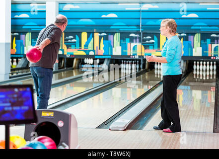 Rückansicht eines reifen Mannes spielen Bowling Spiel im Club Stockfoto