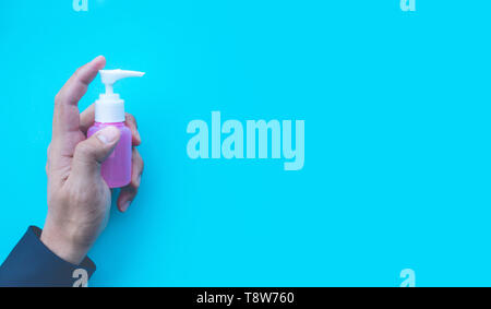 Close up männliche Hand mock up Spray flasche in bunt mit Raum für kreative Ideen im Hintergrund. Stockfoto
