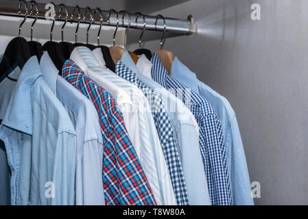 Männer T-Shirts im Schrank hängen im Wohnzimmer Apartment Home Interior Stockfoto
