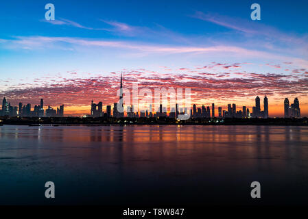 Morgen oder Sonnenaufgang, Dämmerung in Dubai. Schöne farbige wolkiger Himmel über der Innenstadt von Dubai. Lichtschein über Wolkenkratzer. Stockfoto