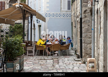 Kotor, Montenegro, 30. April 2019: Gruppe von Touristen Speisen im Freien Restaurant Terrasse in der Altstadt Stockfoto