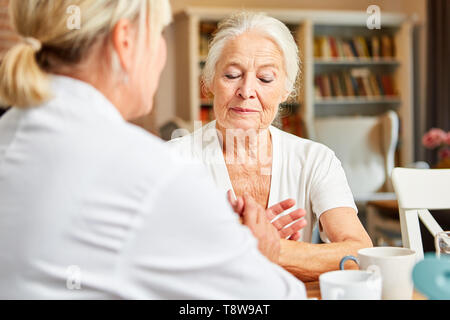 Frau des Pflegedienstes Konsolen traurig Senioren im Pflegeheim Stockfoto