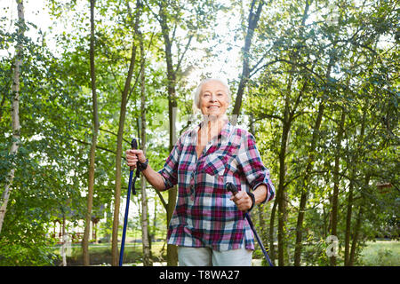 Vital senior Frau schult Ausdauer und Fitness beim Nordic Walking Stockfoto