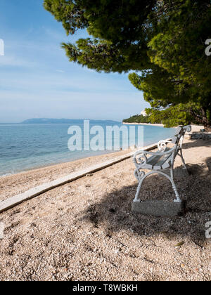 Holzbank am Strand mit Meerblick in Tucepi, Kroatien Stockfoto