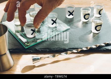 Einen Mann mit einem Tequila shot in einem tic Tack toe Spiel Stockfoto