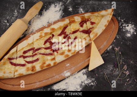 Türkische Pizza ist aufgerufen, Pide mit Käse und Wurst auf dünnem Teig in Form eines Bootes. Stockfoto