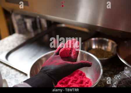 Thema kochen Pralinen Trüffel. Close-up Hand jungen kaukasischen Frau und Mann Kochen mit Tattoo und in Uniform bereitet, macht Runde balltake der Süße Stockfoto