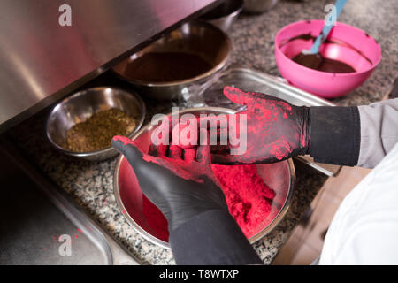 Thema kochen Pralinen Trüffel. Close-up Hand jungen kaukasischen Frau und Mann Kochen mit Tattoo und in Uniform bereitet, macht Runde balltake der Süße Stockfoto