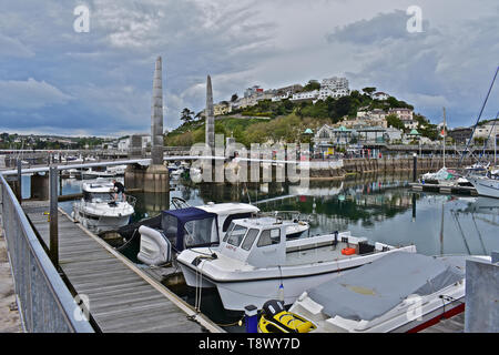 Ein Blick über den Inneren Hafen/Marina bei Torquay mit Yachten bei moorings. Ruhe Stille Wasser mit Reflexionen von Booten und Gebäude auf dem Hügel. Stockfoto