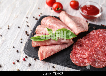 Schiefer Platte mit verschiedenen Arten von Würstchen auf Licht Tabelle Stockfoto