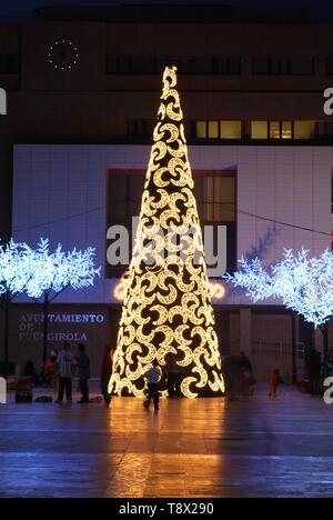 Konische Weihnachtsbaum mit Mond Dekorationen mit dem Rathaus (Ayuntamiento) hinten an der Nacht, Fuengirola, Spanien. Stockfoto