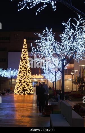 Konische Weihnachtsbaum mit Mond Dekorationen mit dem Rathaus (Ayuntamiento) hinten an der Nacht, Fuengirola, Spanien. Stockfoto