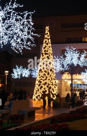 Konische Weihnachtsbaum mit Mond Dekorationen mit dem Rathaus (Ayuntamiento) hinten an der Nacht, Fuengirola, Spanien. Stockfoto