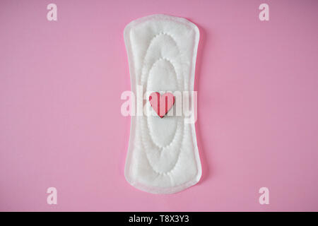 Menstruationszyklus Pad mit roten Herzen auf farbigen Hintergrund Stockfoto