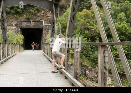 Ein Wander- und Radweg auf der alten Bahnlinie in der Karangahake Gorge, Teil des Hauraki Rail Trail Stockfoto