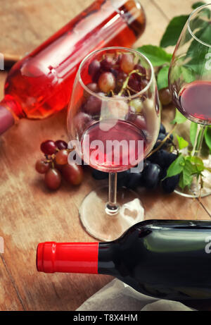 Gläser und Flaschen mit Wein auf hölzernen Tisch Stockfoto