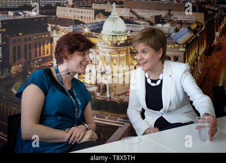 Erster Minister Nicola Sturgeon (rechts) mit Dozentin Maria Economou aus Griechenland während eines Besuchs in Tay House, Glasgow, wo sie mit EU-Staatsangehörigen an der Universität von Glasgow vor der EU-Wahl in der nächsten Woche arbeiten. Stockfoto