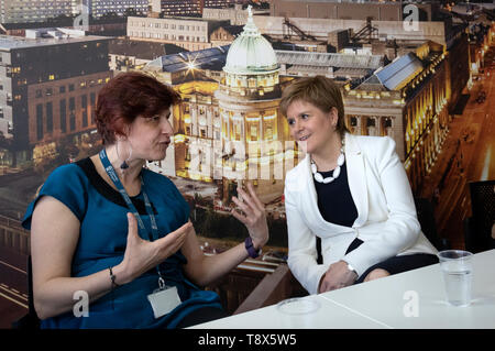 Erster Minister Nicola Sturgeon (rechts) mit Dozentin Maria Economou aus Griechenland während eines Besuchs in Tay House, Glasgow, wo sie mit EU-Staatsangehörigen an der Universität von Glasgow im Vorfeld der nächsten Woche arbeiten met??? s Europawahl. Stockfoto