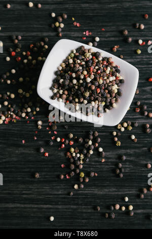 Mischung aus pfefferkörner weiß Schüssel auf Holz- Hintergrund Stockfoto