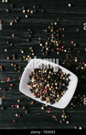 Mischung aus pfefferkörner weiß Schüssel auf Holz- Hintergrund Stockfoto